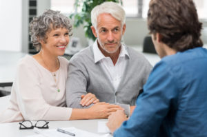 retirement age couple talking to an investment advisor