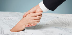 man holding a womans hand pulling her from a pile of paperwork