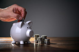 man putting money into a piggy bank